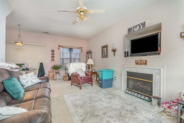 carpeted living room with ceiling fan and a premium fireplace