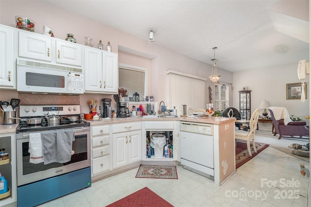 kitchen featuring white cabinetry, hanging light fixtures, and white appliances