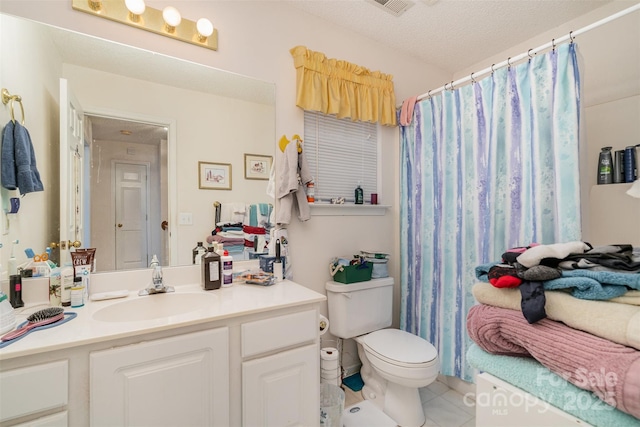 bathroom with tile patterned flooring, vanity, toilet, and a textured ceiling