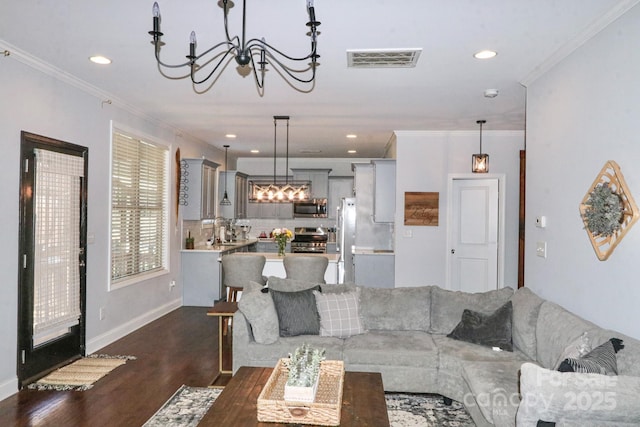 living room featuring ornamental molding, a notable chandelier, and dark hardwood / wood-style floors