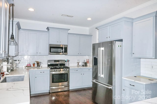 kitchen with dark wood-type flooring, light stone countertops, stainless steel appliances, backsplash, and sink