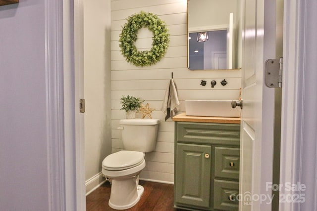 bathroom featuring wood-type flooring, vanity, and toilet