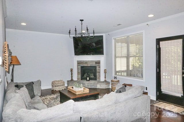 living room featuring crown molding, a stone fireplace, and hardwood / wood-style floors