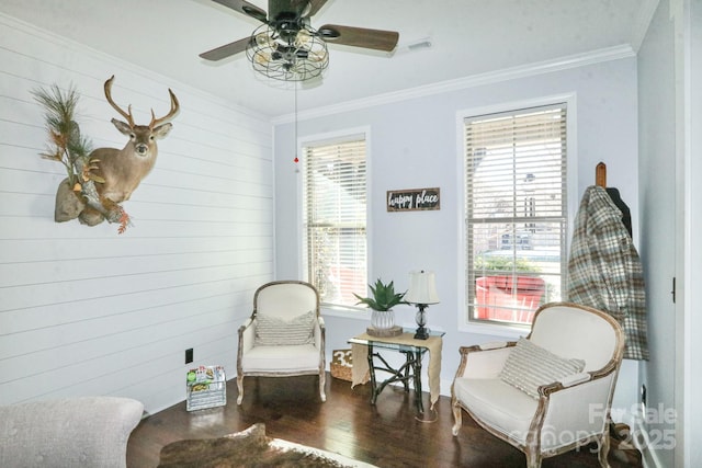 living area featuring crown molding, hardwood / wood-style floors, and ceiling fan