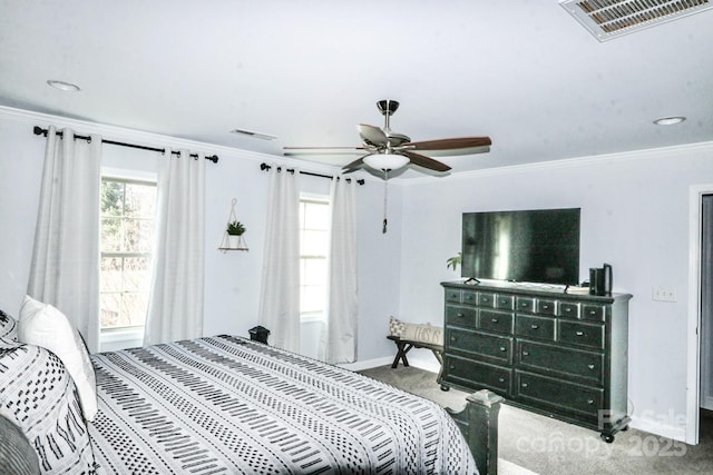 carpeted bedroom with ornamental molding and ceiling fan