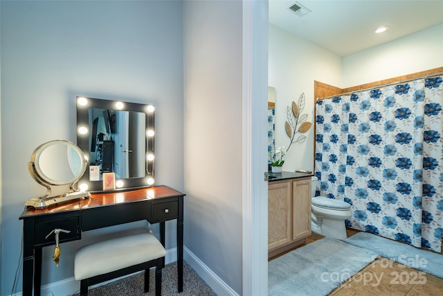 bathroom featuring walk in shower, vanity, and toilet