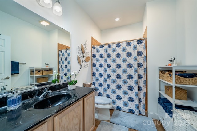 bathroom with vanity, toilet, and walk in shower