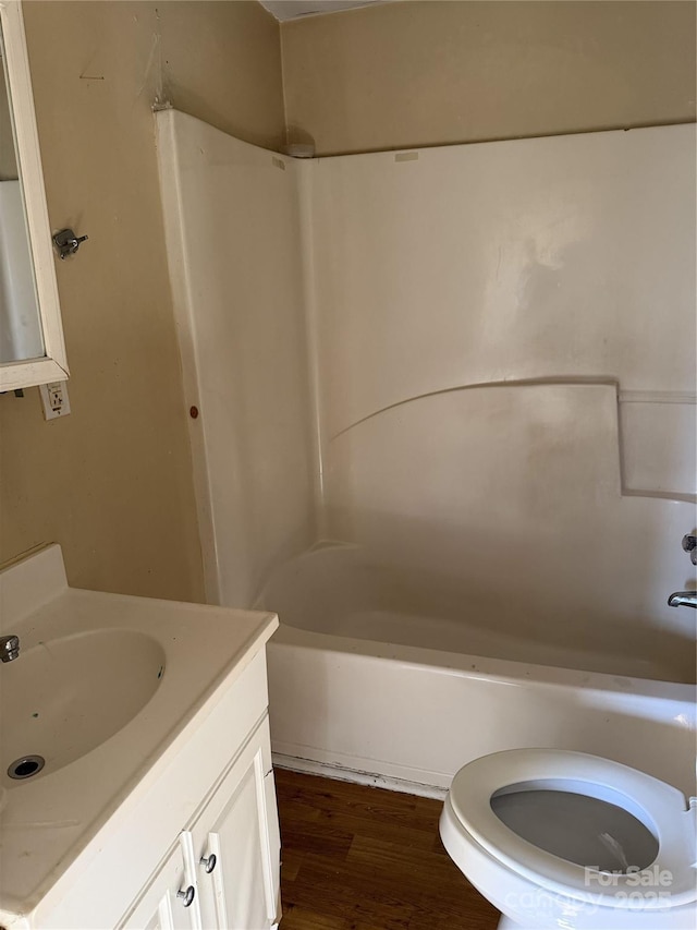 full bathroom with hardwood / wood-style floors, vanity, toilet, and shower / washtub combination