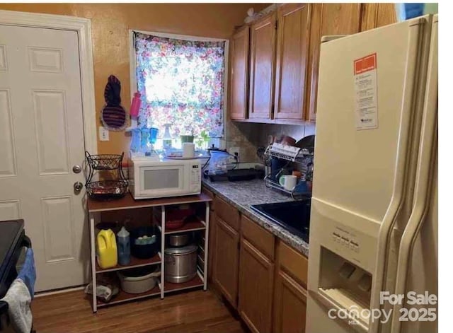 kitchen with dark wood-type flooring, sink, and white appliances