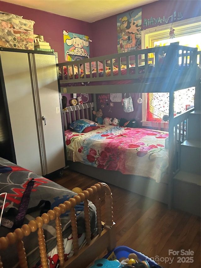 bedroom with dark wood-type flooring and a closet