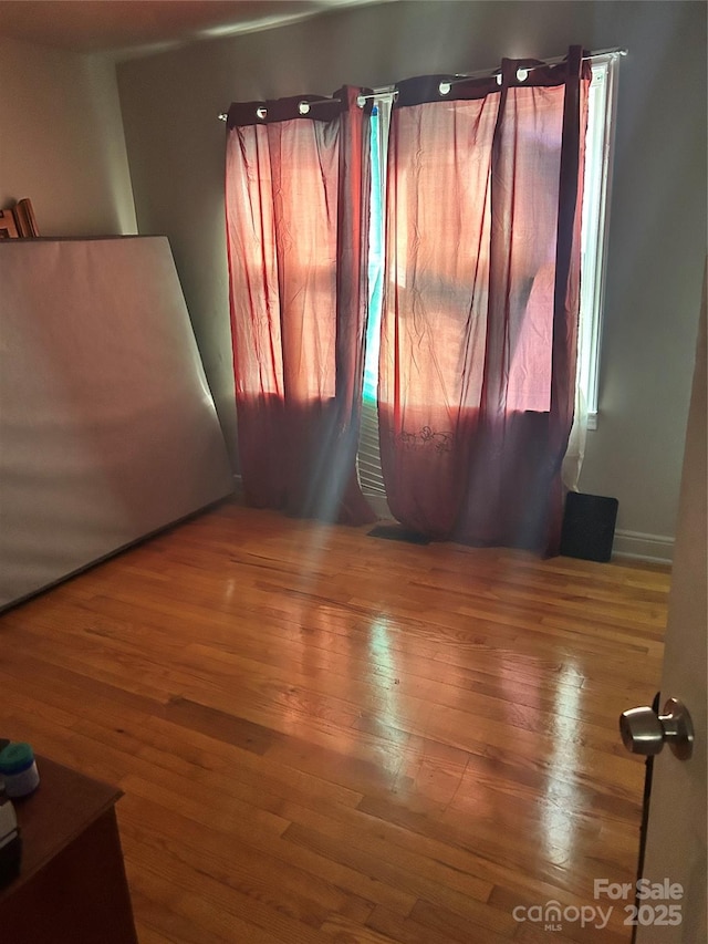 unfurnished room with hardwood / wood-style flooring