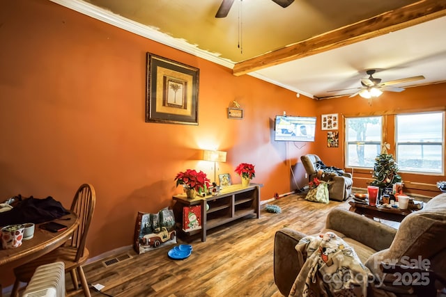 living room featuring hardwood / wood-style floors, ceiling fan, crown molding, and beamed ceiling