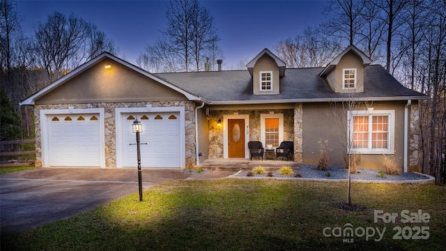 view of front of property with a porch, a garage, and a yard