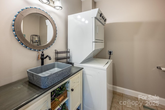 washroom with stacked washer and dryer, light tile patterned flooring, cabinets, and sink