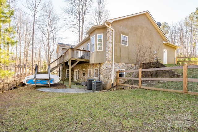 back of property with a yard, central AC unit, and a deck