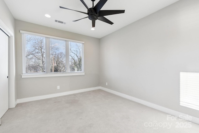 empty room with ceiling fan and light colored carpet