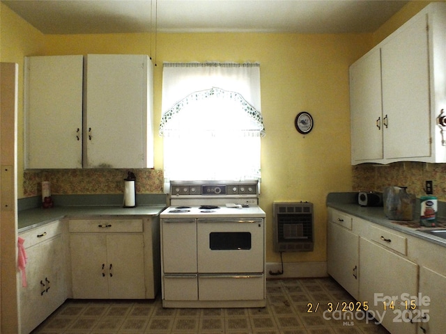 kitchen featuring double oven range, heating unit, white cabinets, and backsplash