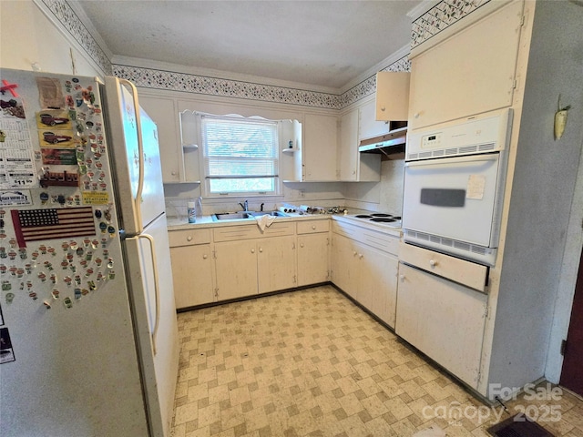 kitchen with ventilation hood, white appliances, sink, and cream cabinets