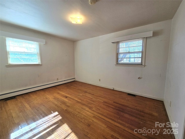 unfurnished room featuring a baseboard radiator and hardwood / wood-style flooring