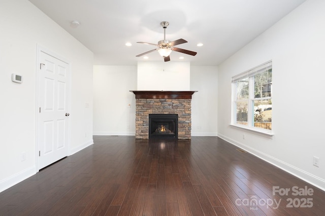 unfurnished living room with ceiling fan, a fireplace, and dark hardwood / wood-style floors