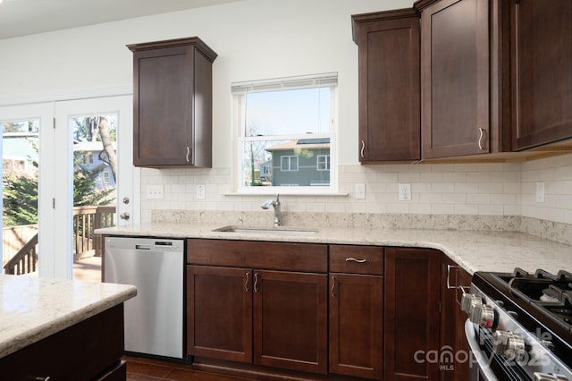 kitchen featuring light stone countertops, sink, decorative backsplash, and stainless steel appliances