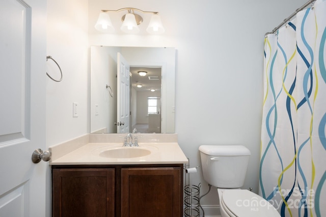 bathroom featuring toilet, vanity, and curtained shower