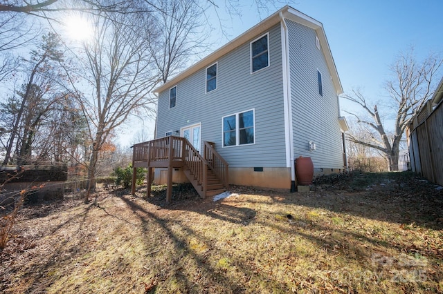 back of house with a wooden deck and a yard