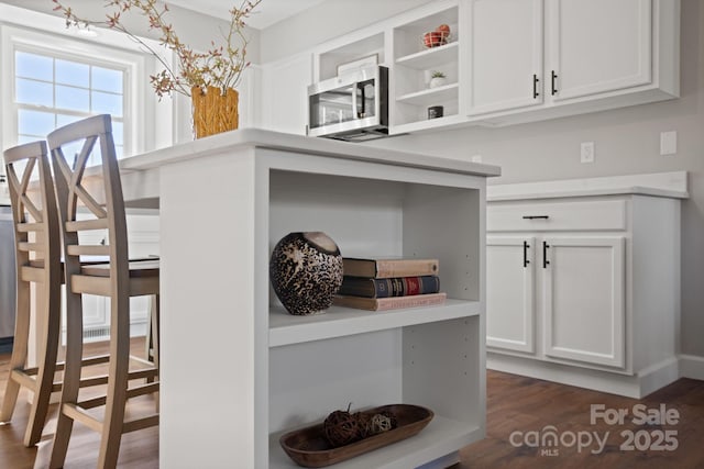 interior space featuring dark hardwood / wood-style flooring and white cabinetry