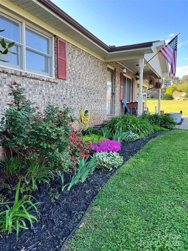 view of side of property featuring a lawn and brick siding