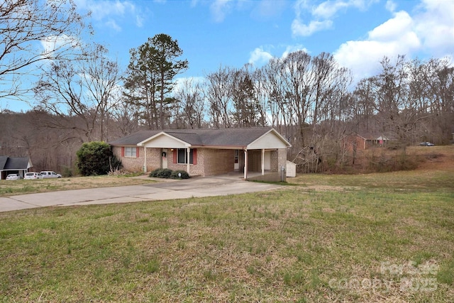 view of front facade with a front yard, brick siding, and driveway