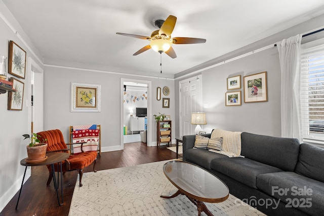 living room featuring dark hardwood / wood-style flooring, ceiling fan, and crown molding