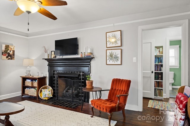 living room featuring dark hardwood / wood-style floors, ceiling fan, and crown molding