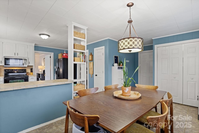 dining area with light tile patterned flooring and ornamental molding