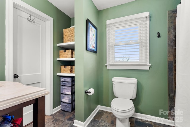 bathroom featuring a shower, vanity, and toilet