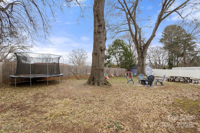 view of yard with a trampoline and a shed