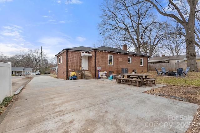 rear view of house with a patio area, an outdoor fire pit, and cooling unit