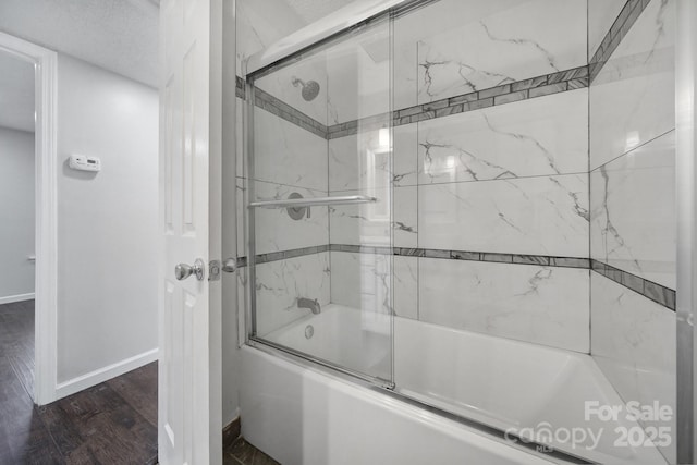 bathroom with combined bath / shower with glass door and hardwood / wood-style floors