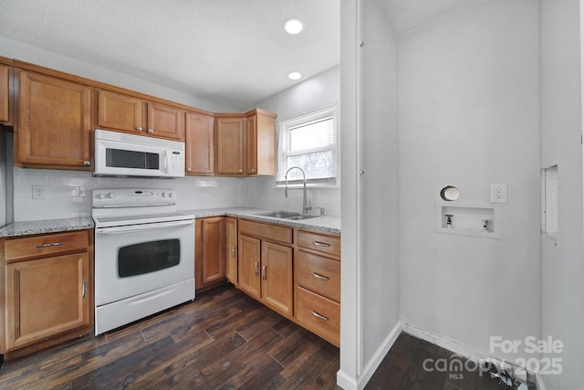 kitchen featuring light stone countertops, sink, dark hardwood / wood-style floors, white appliances, and decorative backsplash