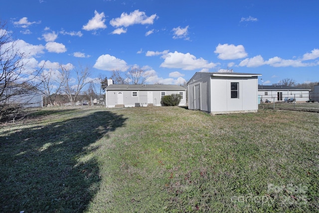 rear view of property featuring a yard and a shed