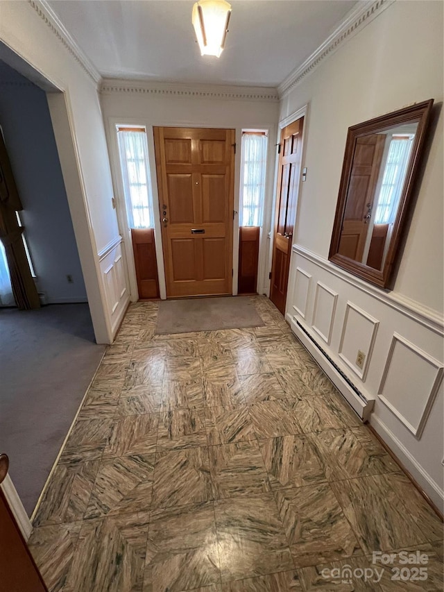 foyer with a baseboard radiator and ornamental molding