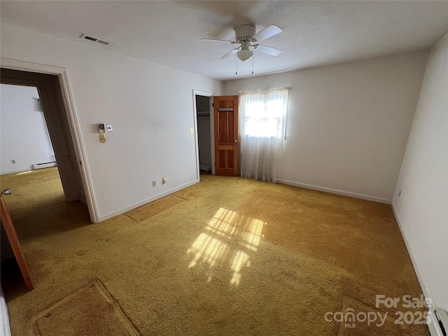 unfurnished bedroom featuring ceiling fan, light colored carpet, and a baseboard heating unit