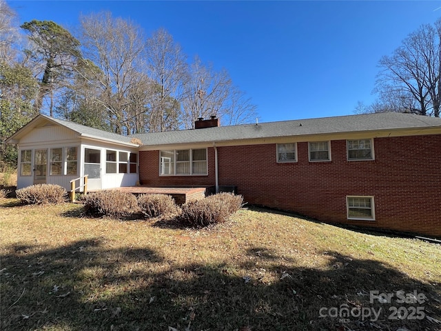 rear view of property with a yard and a sunroom