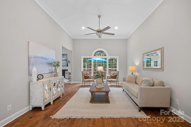 living room featuring ceiling fan, dark hardwood / wood-style flooring, and ornamental molding