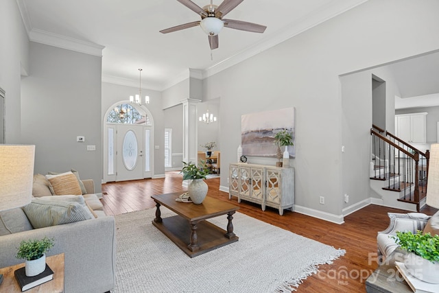 living room with crown molding, ceiling fan with notable chandelier, and hardwood / wood-style flooring