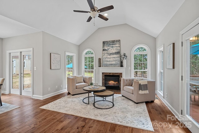 living room featuring vaulted ceiling, ceiling fan, a fireplace, and dark hardwood / wood-style floors