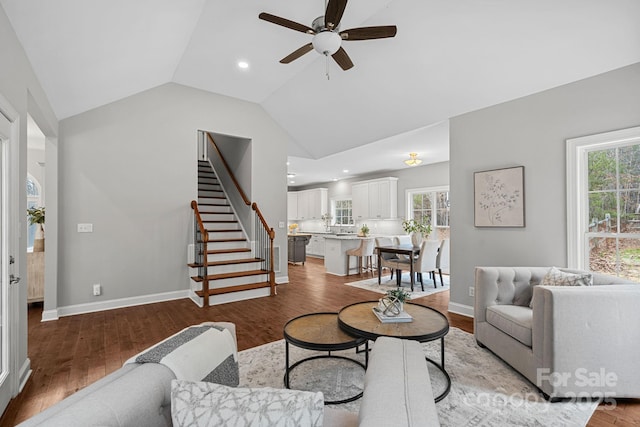 living room featuring ceiling fan, lofted ceiling, and light wood-type flooring