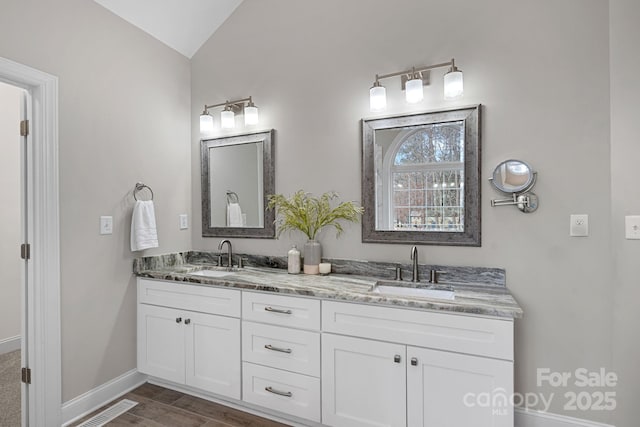 bathroom featuring lofted ceiling and vanity