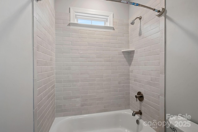 bathroom with toilet and tiled shower / bath combo