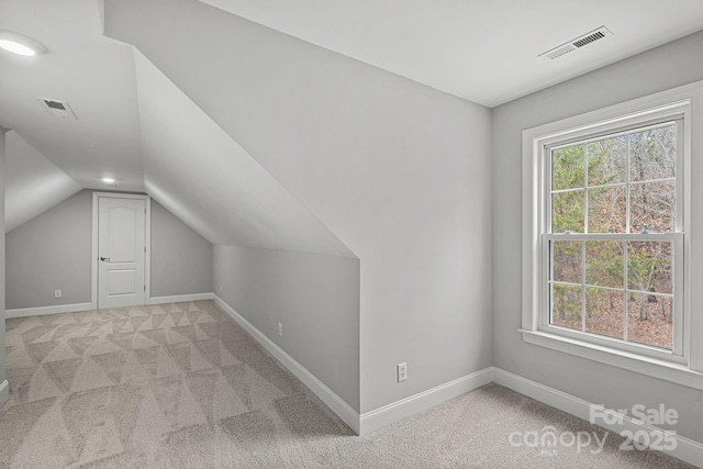 bonus room featuring light colored carpet and vaulted ceiling