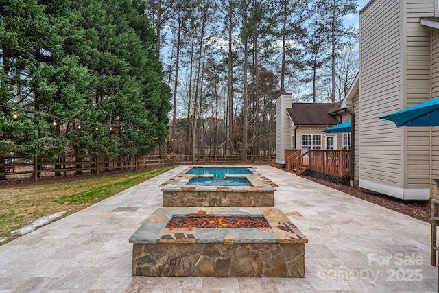 view of swimming pool with a patio area, a wooden deck, and an outdoor fire pit